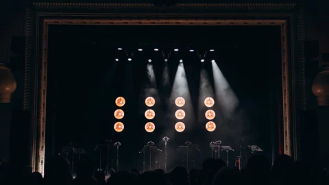 Illuminazione professionale su palco durante un evento indoor